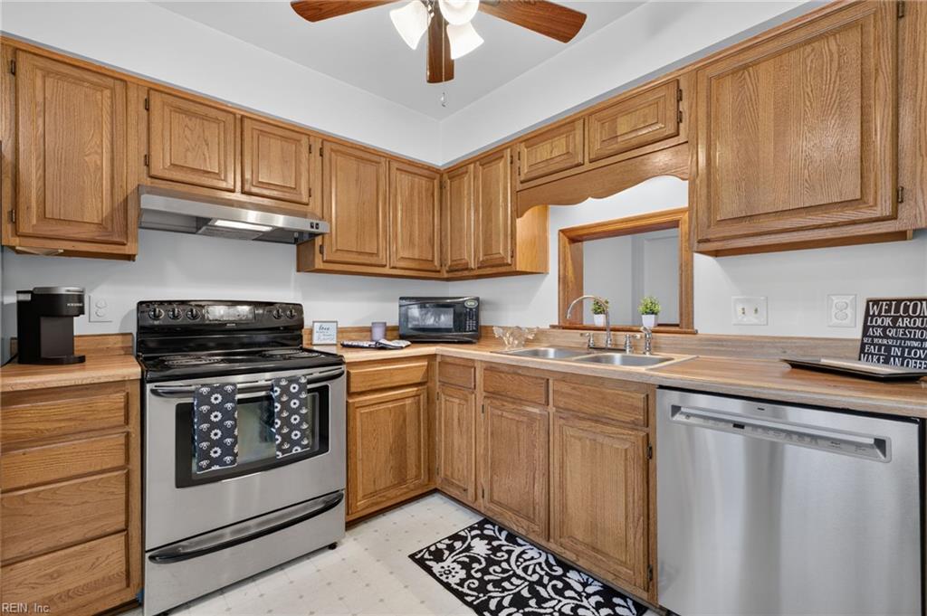 Kitchen with warm wood cabinets, stainless-steel appliances, and a patterned runner.
