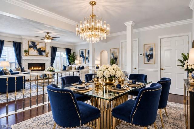 Formal dining room with navy upholstered chairs, a glass-top table, chandelier, and adjoining living room.