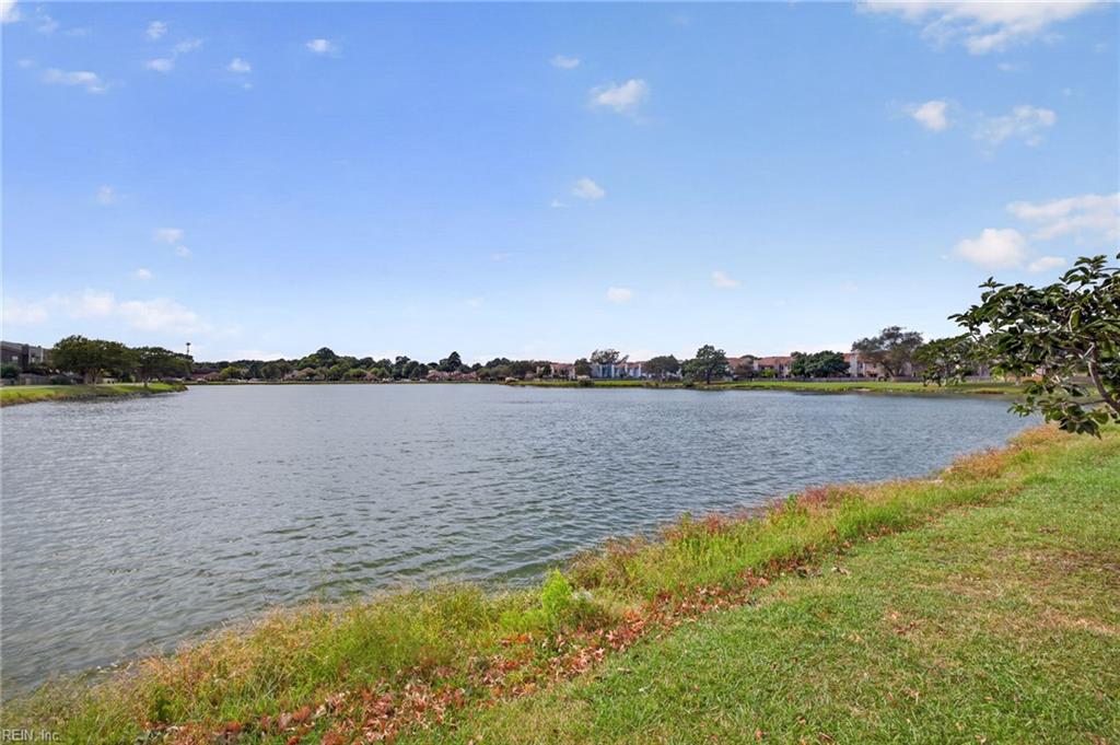 Neighborhood pond with grassy shoreline and homes across the water