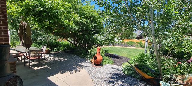 Shaded backyard patio with outdoor seating, gravel garden, chiminea, and hammock.