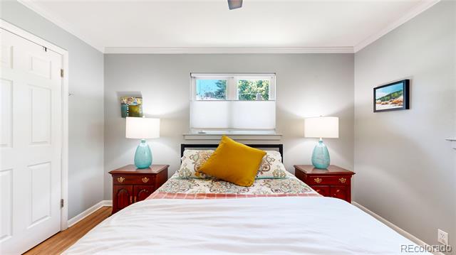 Bedroom with floral bedding, a mustard-yellow pillow, matching red nightstands, and a window above the bed.
