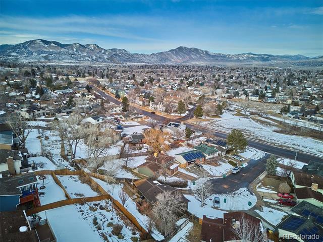 Snow-covered neighborhood and homes with a mountain range in the distance.