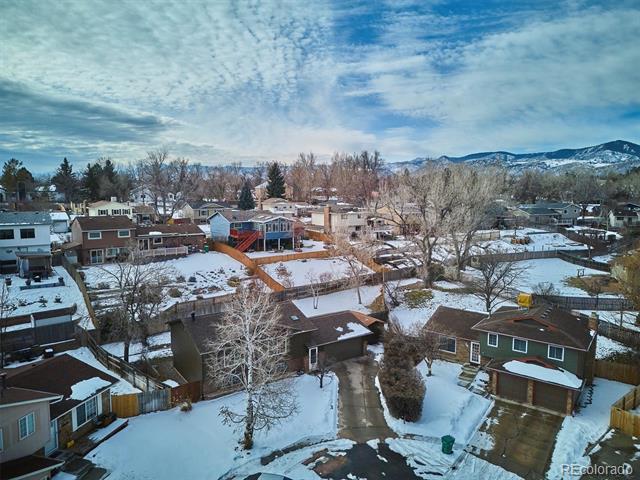 Aerial view of a snow-covered neighborhood with mountains in the distance.