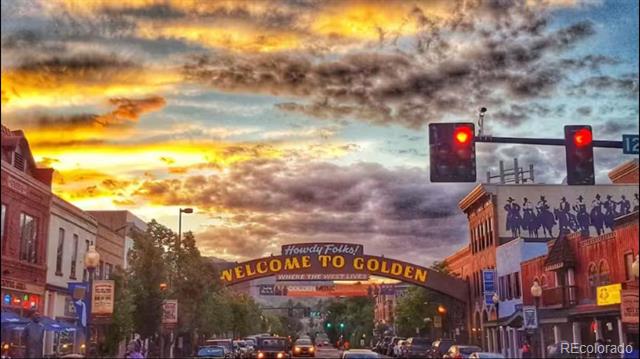 Downtown Golden welcome sign beneath a dramatic sunset sky.
