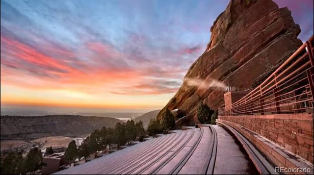 Red Rocks Amphitheatre seating and sandstone formations beneath a colorful sunset sky.
