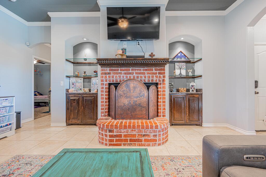 Living room with a red brick fireplace, built-in cabinets, and television above the mantel.