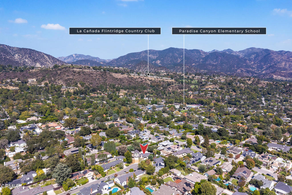 Aerial view of a La Cañada Flintridge neighborhood, with a red marker and mountains in the distance.