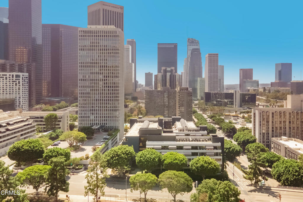 Downtown Los Angeles skyline viewed from above, with office towers and tree-lined streets.