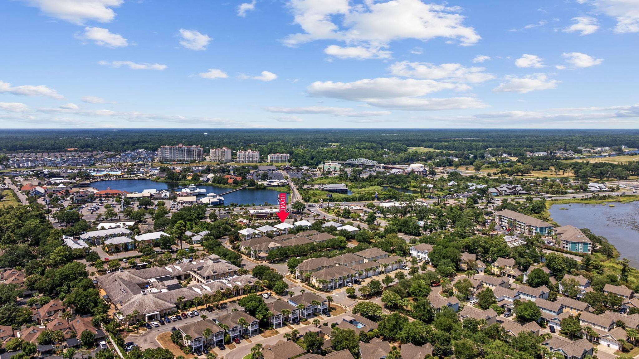 Aerial view of the home marked by an arrow among neighborhood homes and waterways.