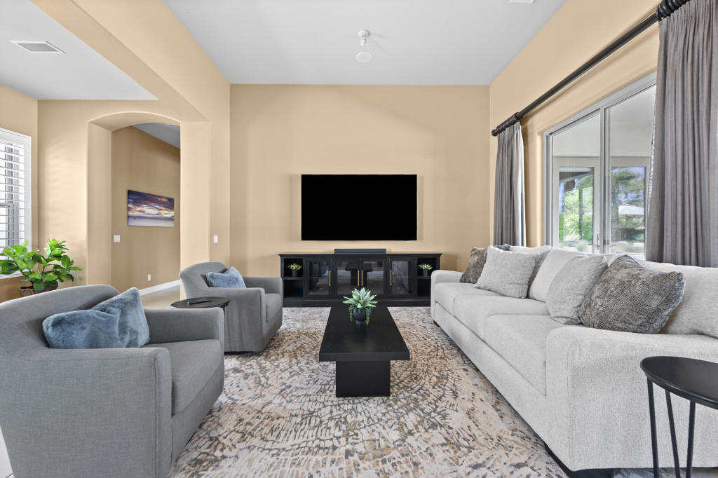 Furnished living room with gray sofas, a black coffee table, and a wall-mounted television.