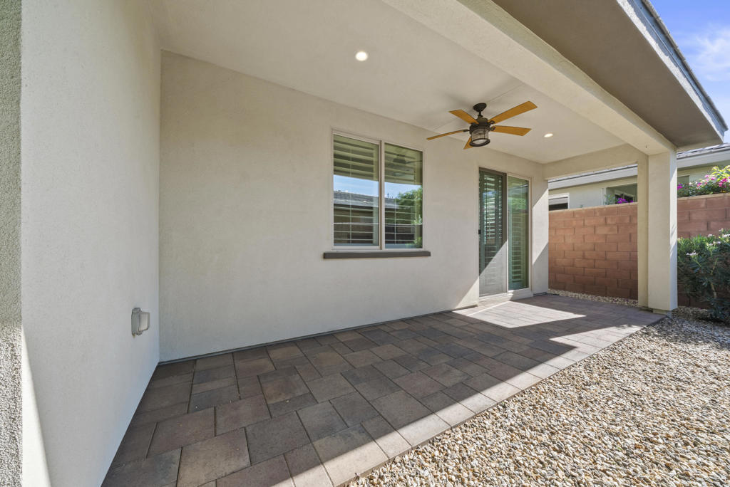 Covered patio with a ceiling fan, tiled floor, and sliding glass door.