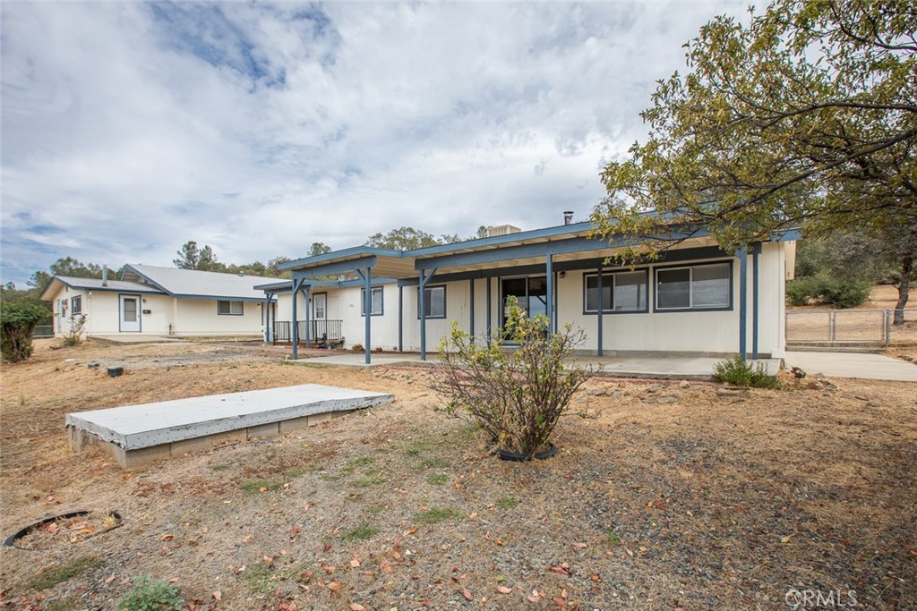 Single-story home with a blue-trimmed covered patio and a dry yard.