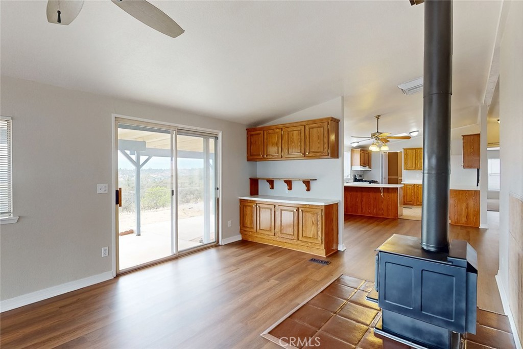 Living area with wood floors, built-in cabinets, a freestanding wood stove, and sliding doors to a patio.