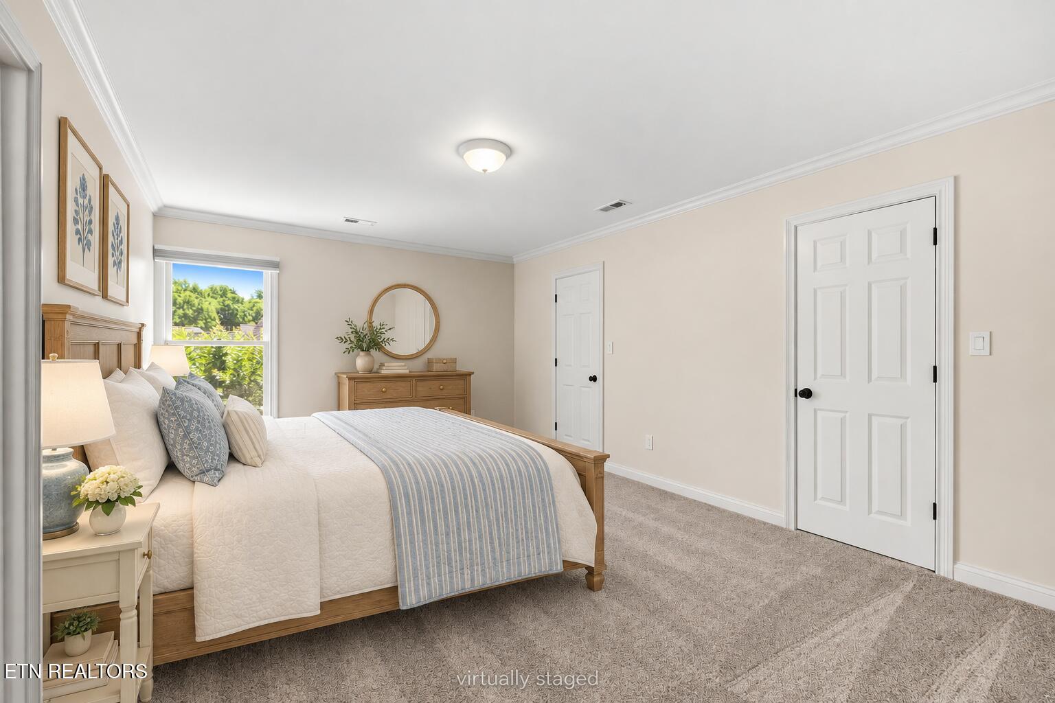 Bedroom with white bedding, a blue striped runner, and a wooden dresser beneath a round mirror.