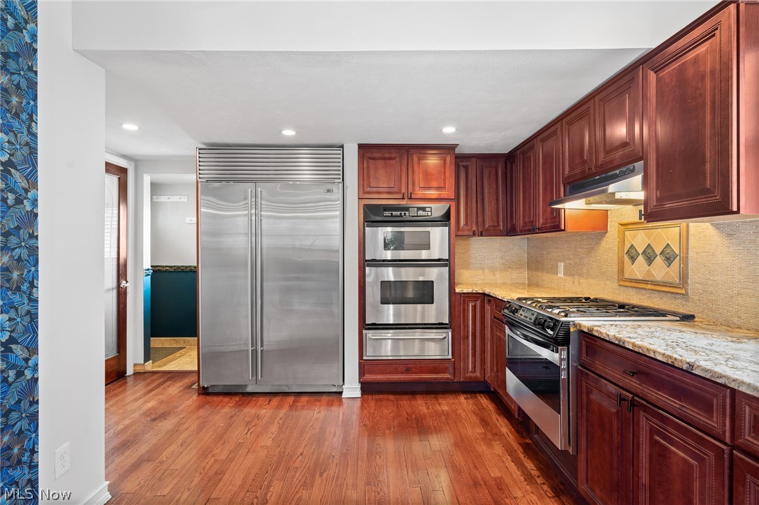 Kitchen with wood cabinets, stainless steel appliances, and hardwood flooring.