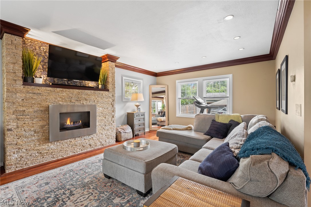 Living room with a stone fireplace, gray sectional, and large windows.
