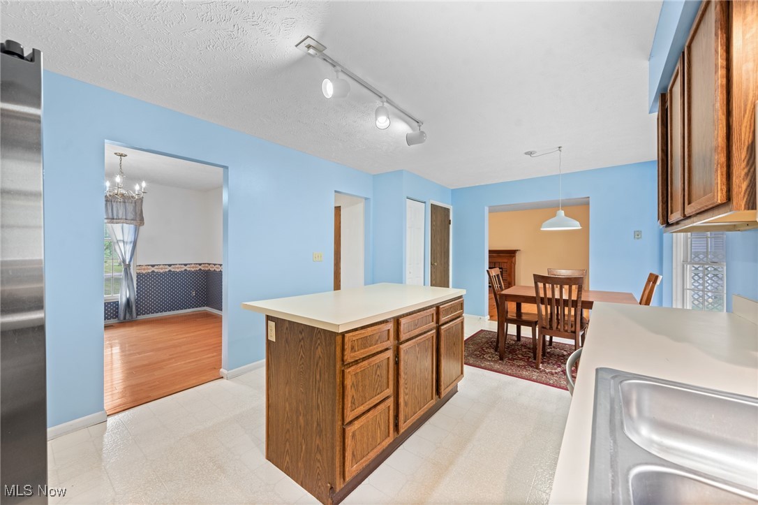Kitchen with a wood-paneled island and dining area beyond.