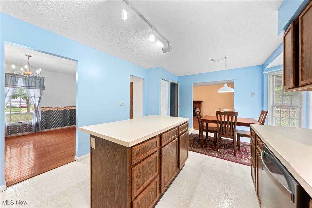Kitchen with a large wood island, blue walls, and an adjoining dining area.