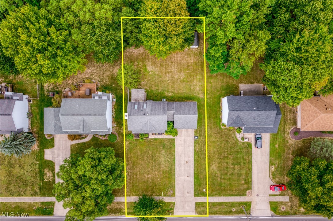 Aerial view of the Whitney Road home and its yellow-outlined lot, bordered by mature trees and neighboring houses.