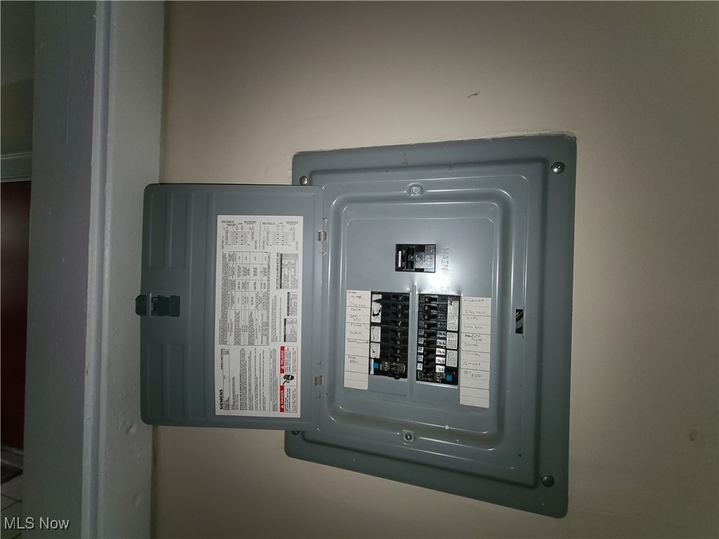 Open Siemens breaker panel with rows of circuit breakers and handwritten labels.