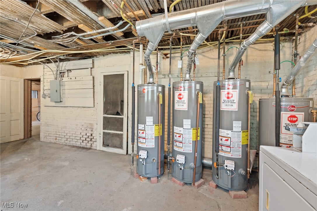 Basement utility room with multiple water heaters and exposed ductwork.