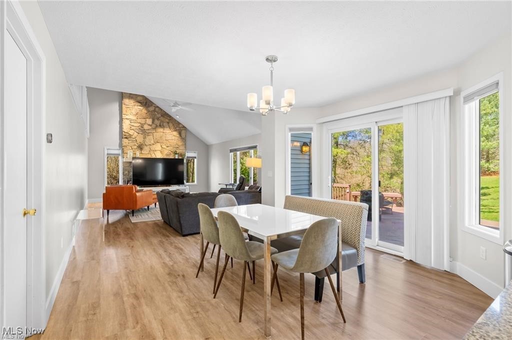 Open living and dining room with a stone accent wall and sliding doors to the patio.