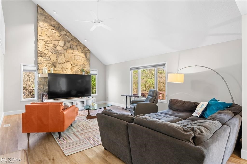Living room with a vaulted ceiling, stone fireplace wall, and gray sectional sofa.