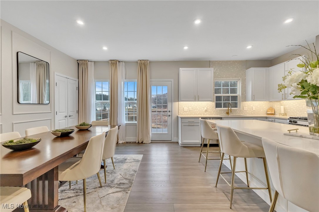 Open-plan kitchen and dining area with a large white island and wood dining table.