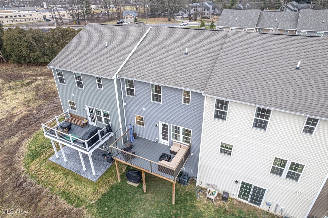 Rear of a two-story house with two elevated decks and outdoor seating.