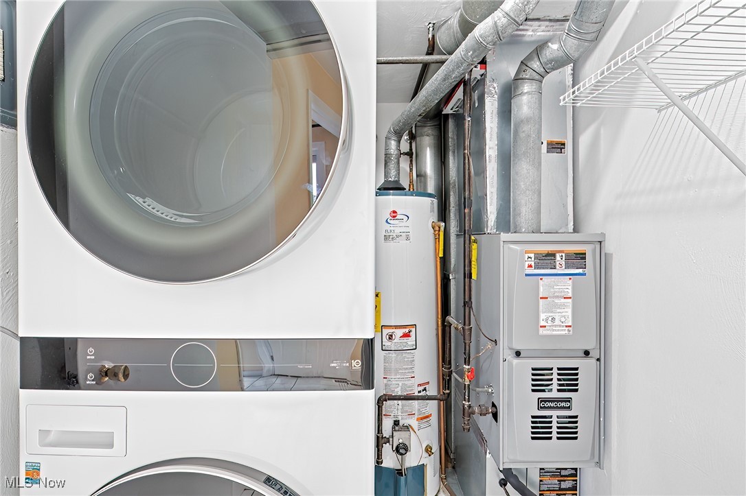 Laundry and utility area with a front-loading washer and dryer beside the water heater and furnace.