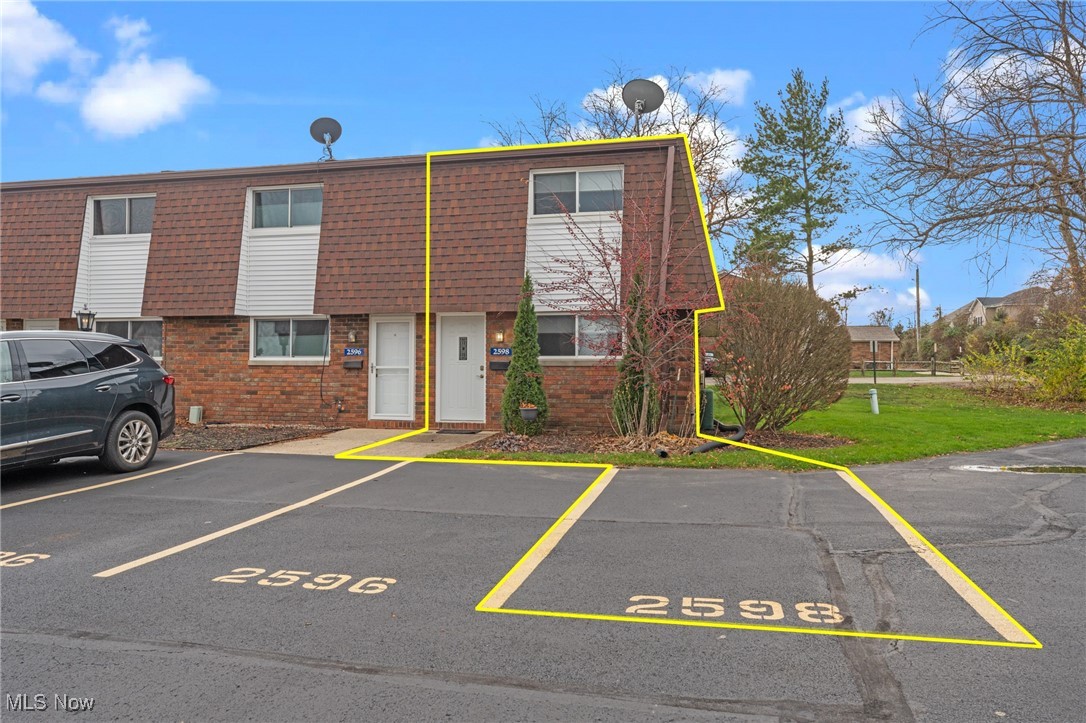 Outlined two-story brick townhouse at 2598 Shakespeare Lane with its numbered parking space.