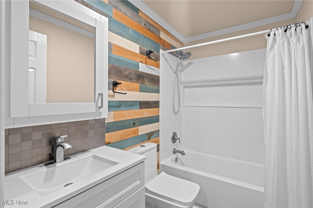 Bathroom with a white tub and vanity beside a colorful horizontal wood-plank accent wall.