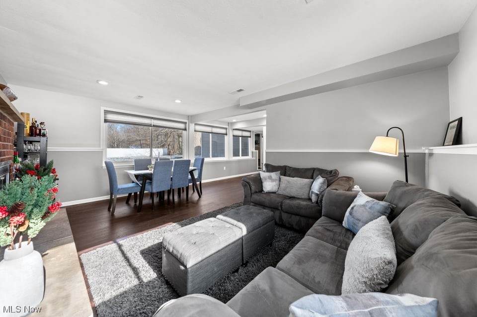 Living room with a large gray sectional and a dining area beside snow-facing windows.