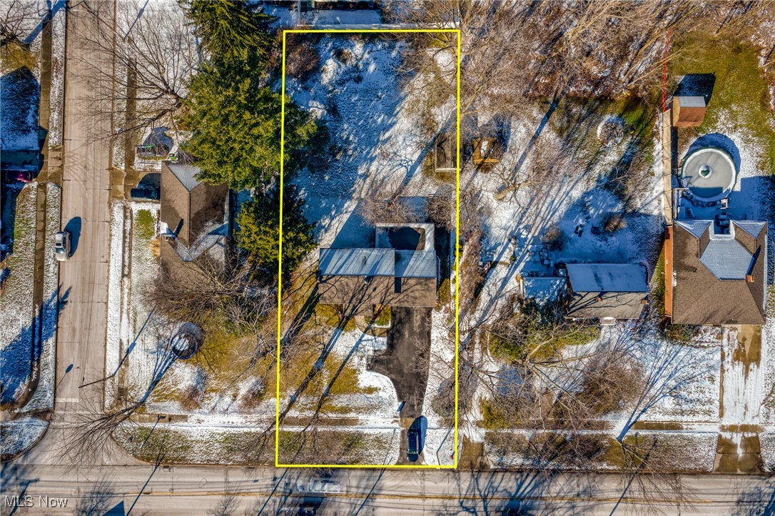 Aerial view of a snow-dusted home and lot outlined in yellow.
