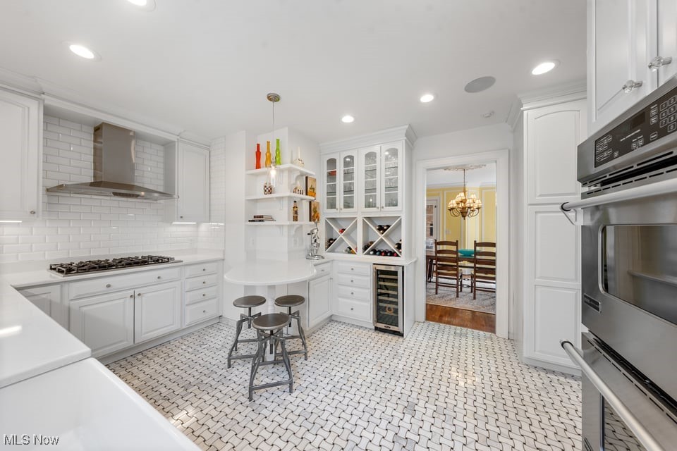 White kitchen with a curved seating peninsula, built-in wine storage, and geometric tile flooring.