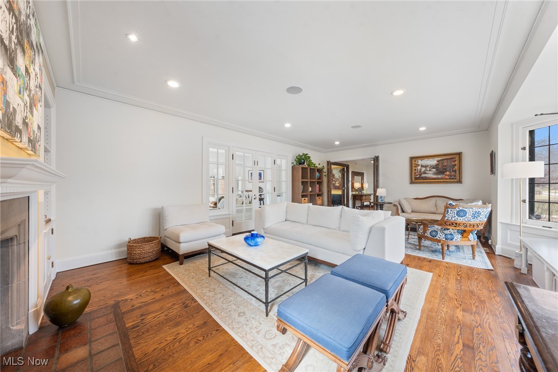 Living room with white sofas, a fireplace, and blue upholstered ottomans.