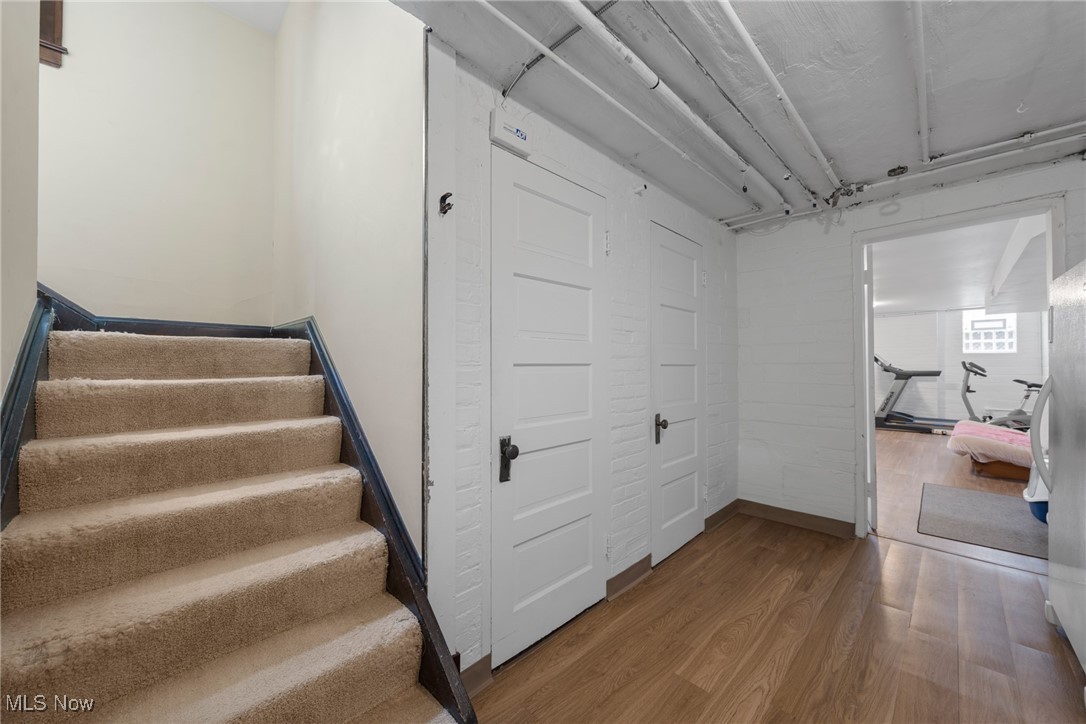 Hallway with carpeted stairs and white paneled doors, opening to a workout room.