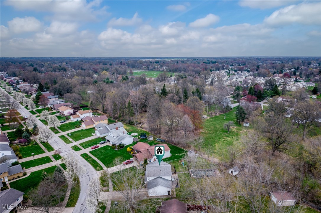 Aerial view of 523 Catlin beside a wooded area and residential neighborhood.