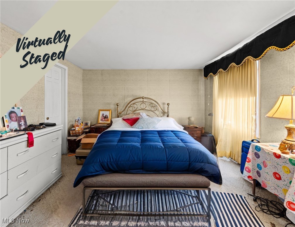 Bedroom with a blue comforter, ornate metal headboard, white dresser, and gold curtains; virtually staged.