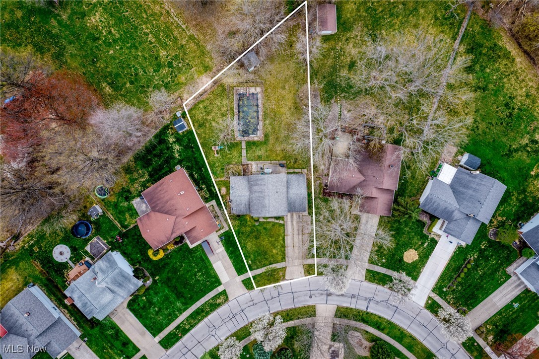 Aerial view of a home and backyard pool within a white property boundary.