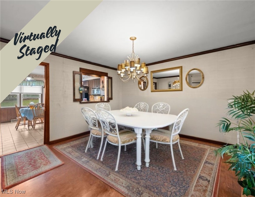 Virtually staged dining room with a white table, ornate chairs, chandelier, and adjoining breakfast nook.