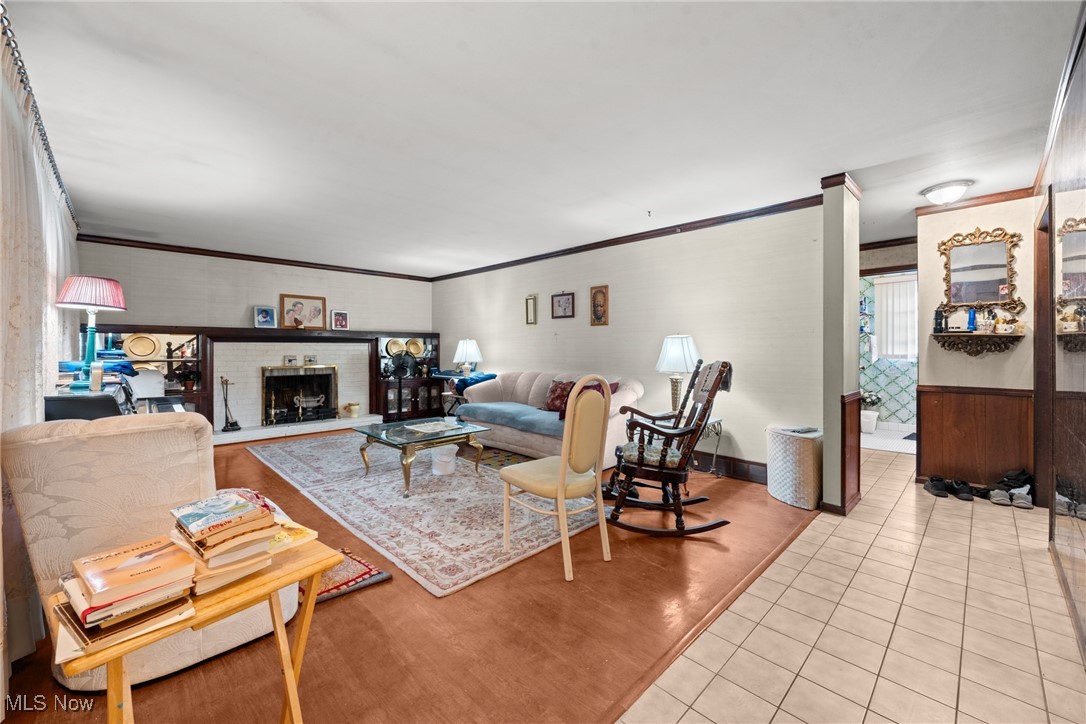 Living room with a fireplace, dark built-in shelving, and a patterned rug.