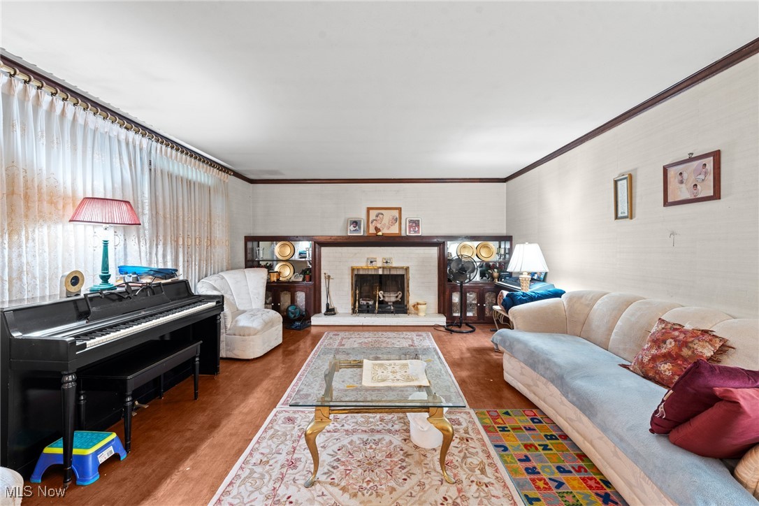 Living room with a black grand piano, fireplace, built-in shelves, and cream seating.