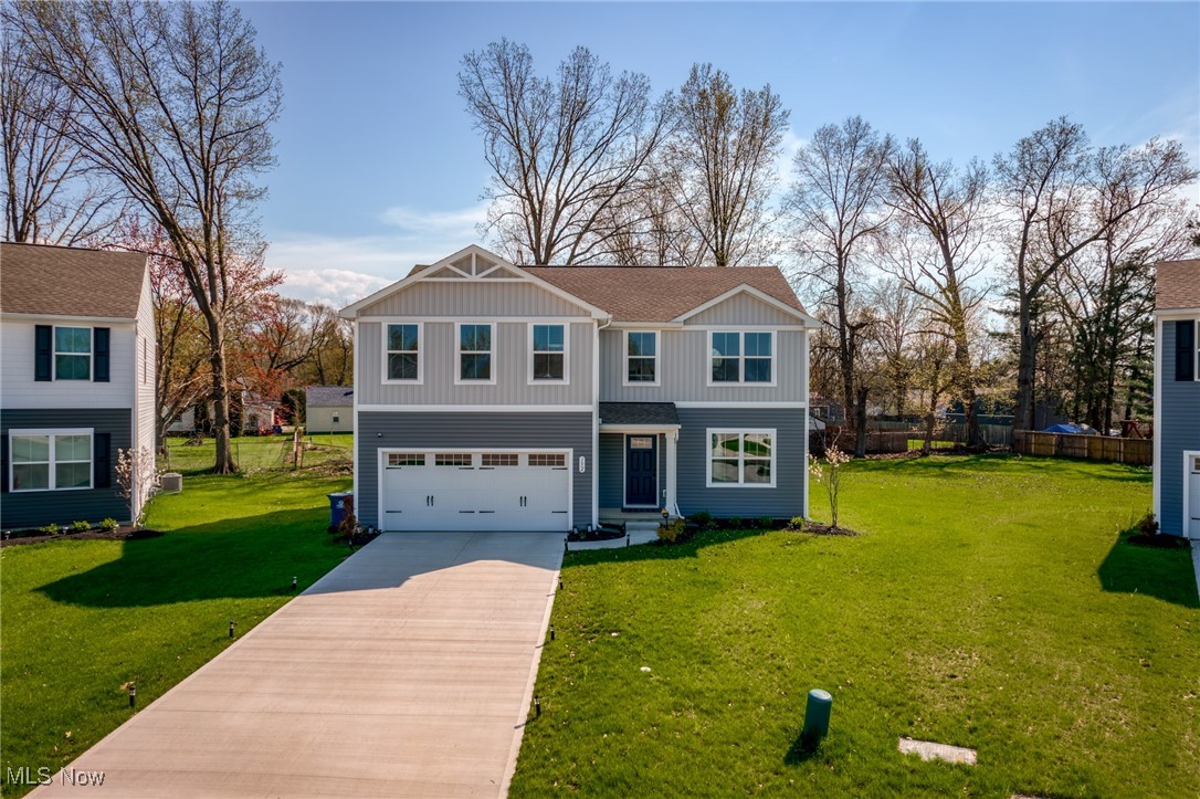 Two-story gray-and-white home with a double garage and long driveway.