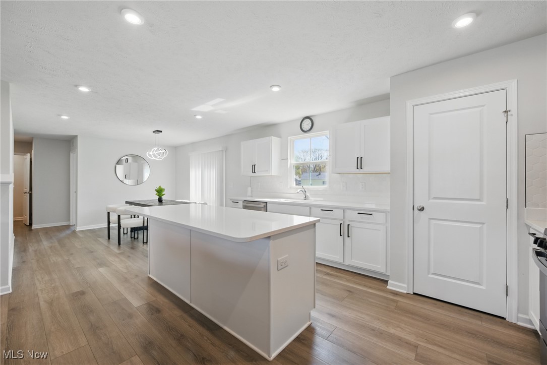 Bright white kitchen with a large island and dining area.