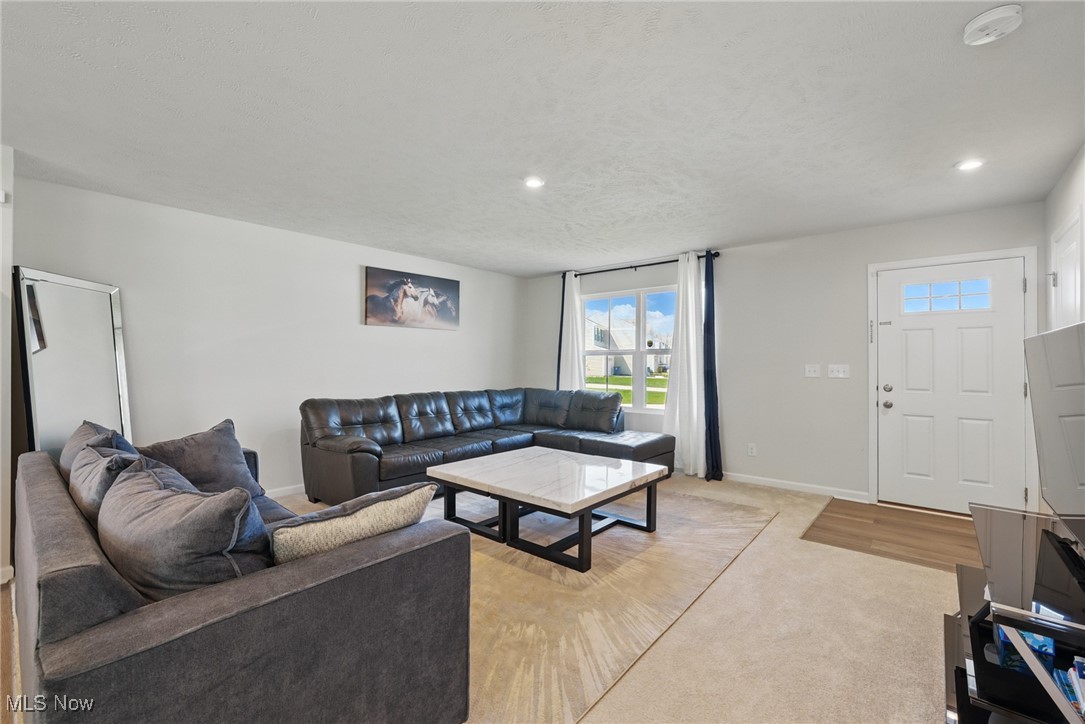 Living room with two sofas, a marble-look coffee table, and a window beside the front door.