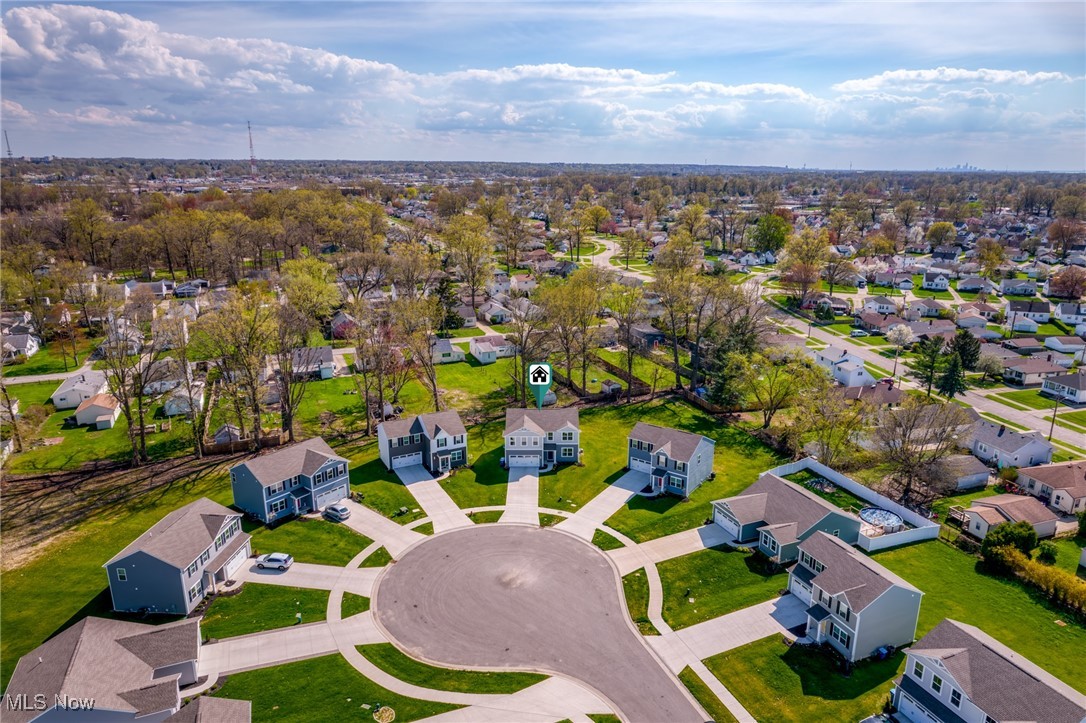 Aerial view of a cul-de-sac with detached homes and a marked house near the center.