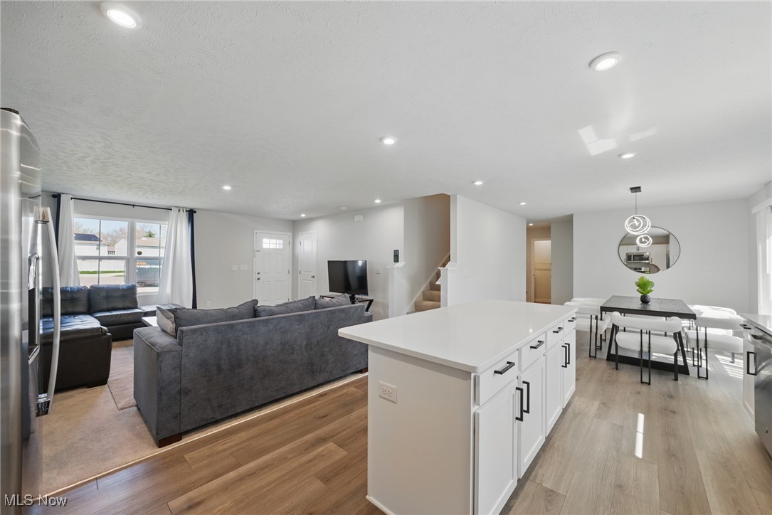 Open-plan kitchen, dining, and living area with a large island and gray sectional.