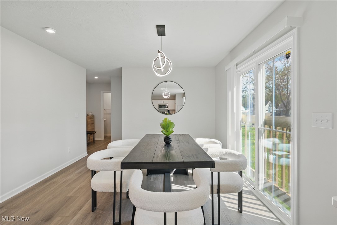 Dining room with a dark table, white chairs, and sliding glass doors to the yard.