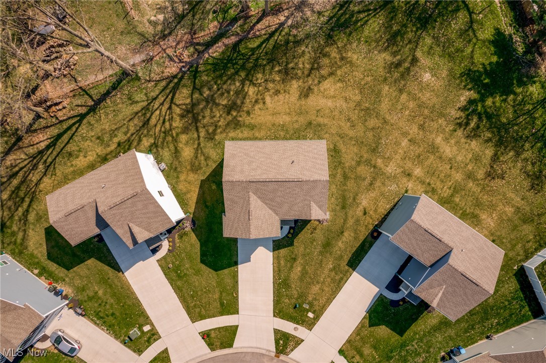 Aerial view of a cul-de-sac with the listed home centered among neighboring houses and lawns.